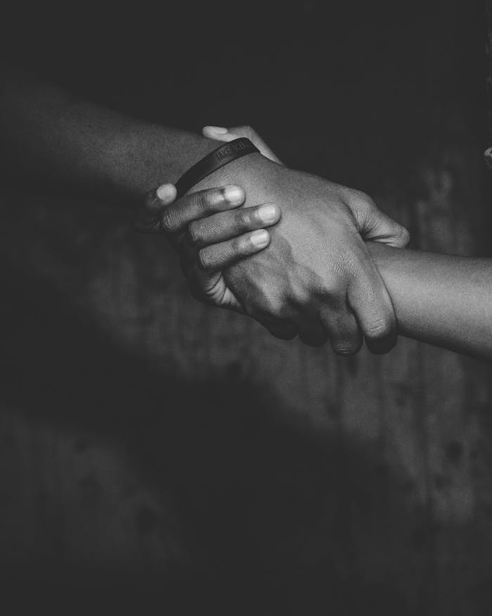 A powerful black and white image of two hands holding, symbolizing unity.